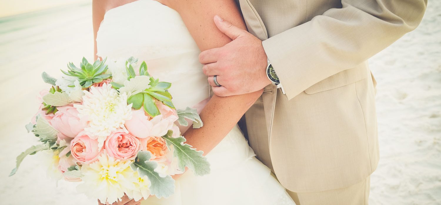 Bride and Groom with a bouquet of flowers on the white sandy beaches of Northwest Florida